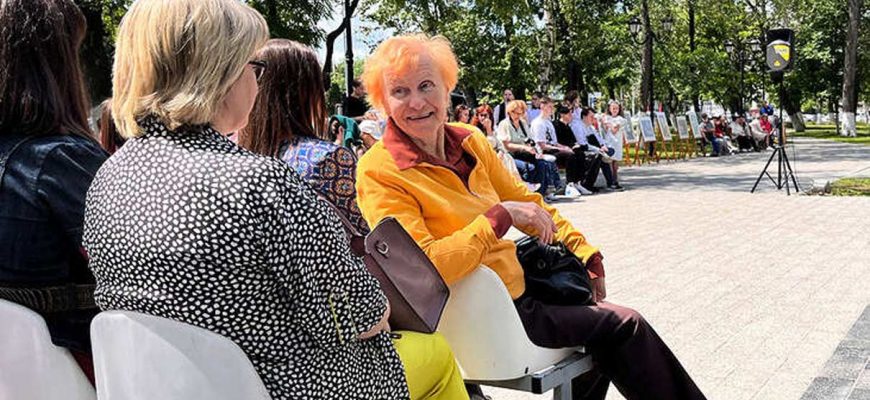 пенсионерка в сквере улыбается