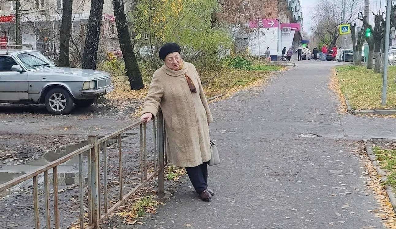 Пенсионерка устала и облокотилась на забор